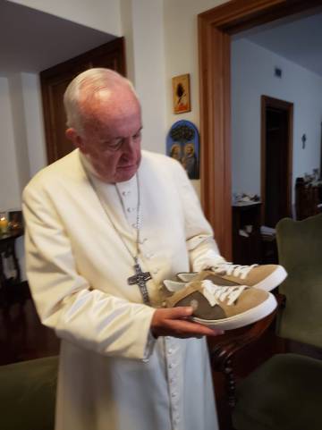El Papa al recibir las zapatillas.
