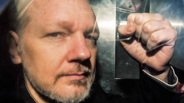Assange, camino de un tribunal en Londres.