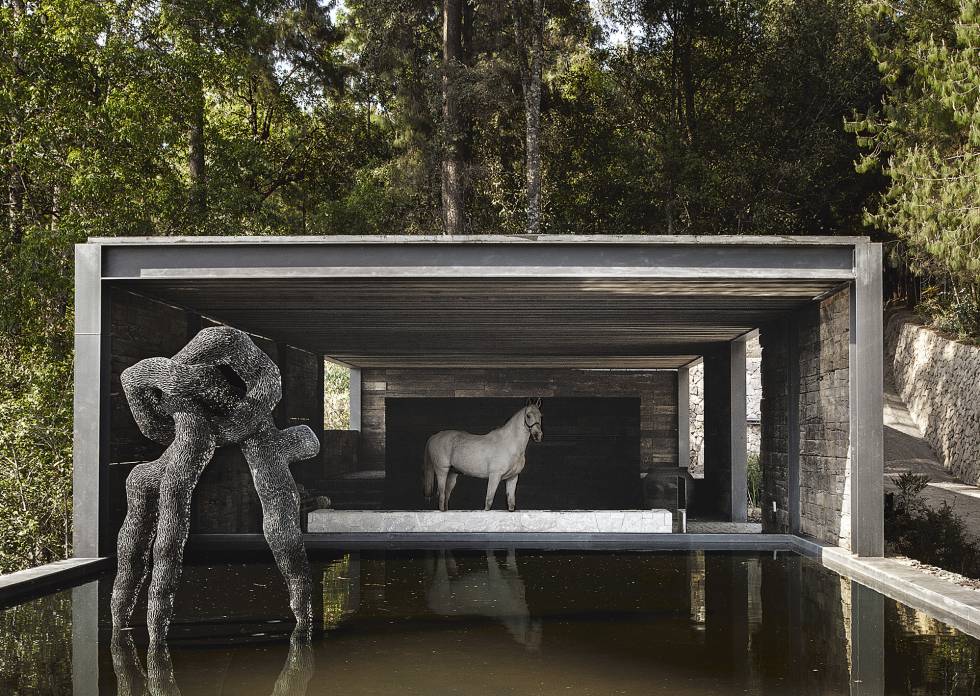 O estábulo com piscina. Tão grande quanto o interior é a varanda deste estábulo construído com dormentes de trilhos reciclados que suportam a cobertura que sombreia a estrebaria. E tão importante quanto a ideia de abrigo é a água, uma grande piscina em que se refletem o cavalo e quem cuida dele. A CC Arquitectos projetou uma porta larga para o pavilhão El Mirador, em uma colina a sudoeste da Cidade do México. A partir dessa estrutura, a natureza entra através das rachaduras na madeira dos dormentes e muda com as estações do ano, enquanto a água reflete as mudanças ao longo do dia.