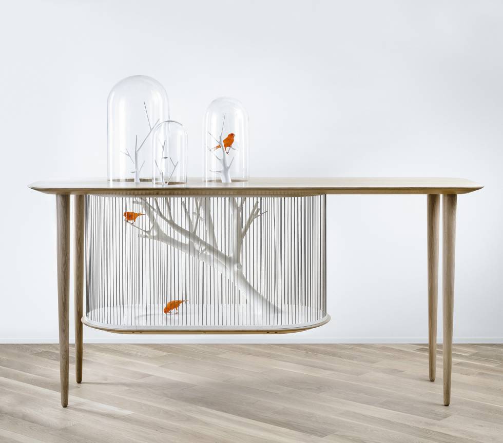 A mesa que também é gaiola de pássaros. Grégoire de Lafforest é um projetista e designer de interiores francês acostumado a trabalhar com artesãos para clientes que procuram reinventar o conceito de luxo. Esta mesa de carvalho maciço é ao mesmo tempo um móvel inesperado –quase surrealista– e uma gaiola para que pássaros –coloridos– fiquem empoleirados em um galho em branco lacado cercado por cabos tensionados de aço inoxidável. O resultado é contraditório: destaca os pássaros e lhes dá mais espaço, tornando-os ao mesmo tempo um ornamento a mais na decoração.