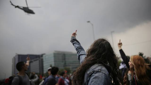 Manifestantes gesticulan a un helicóptero.