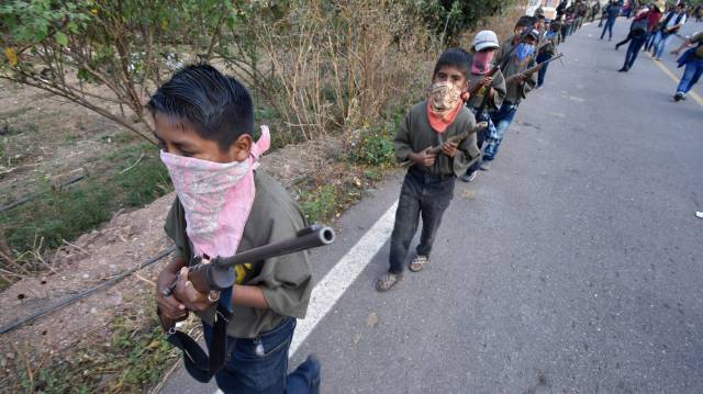 Un menor carga un rifle en Guerrero.