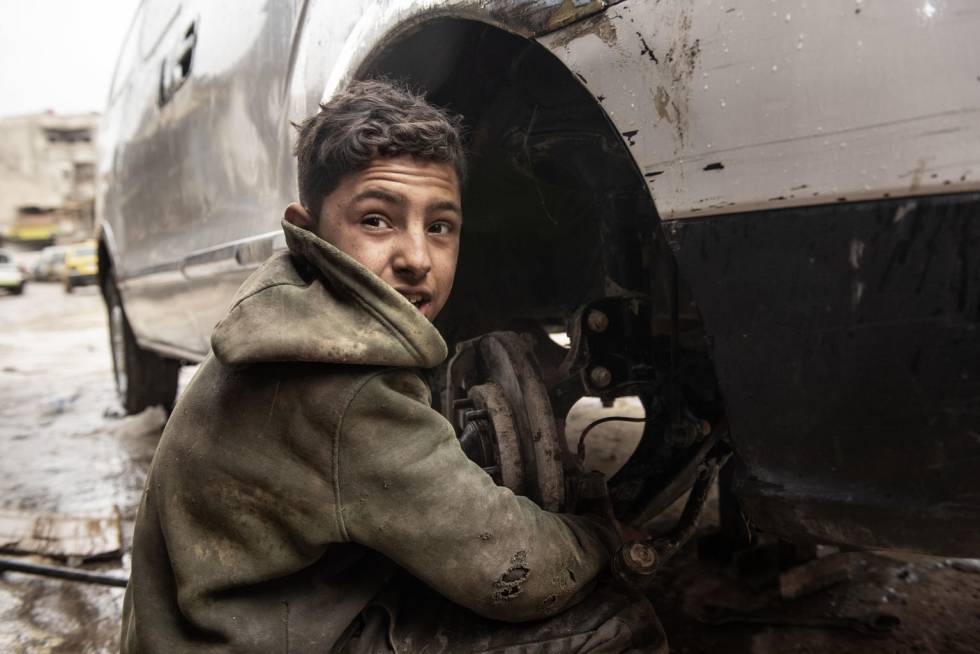 Imad, con 13 años, trabaja en un taller mecánico.