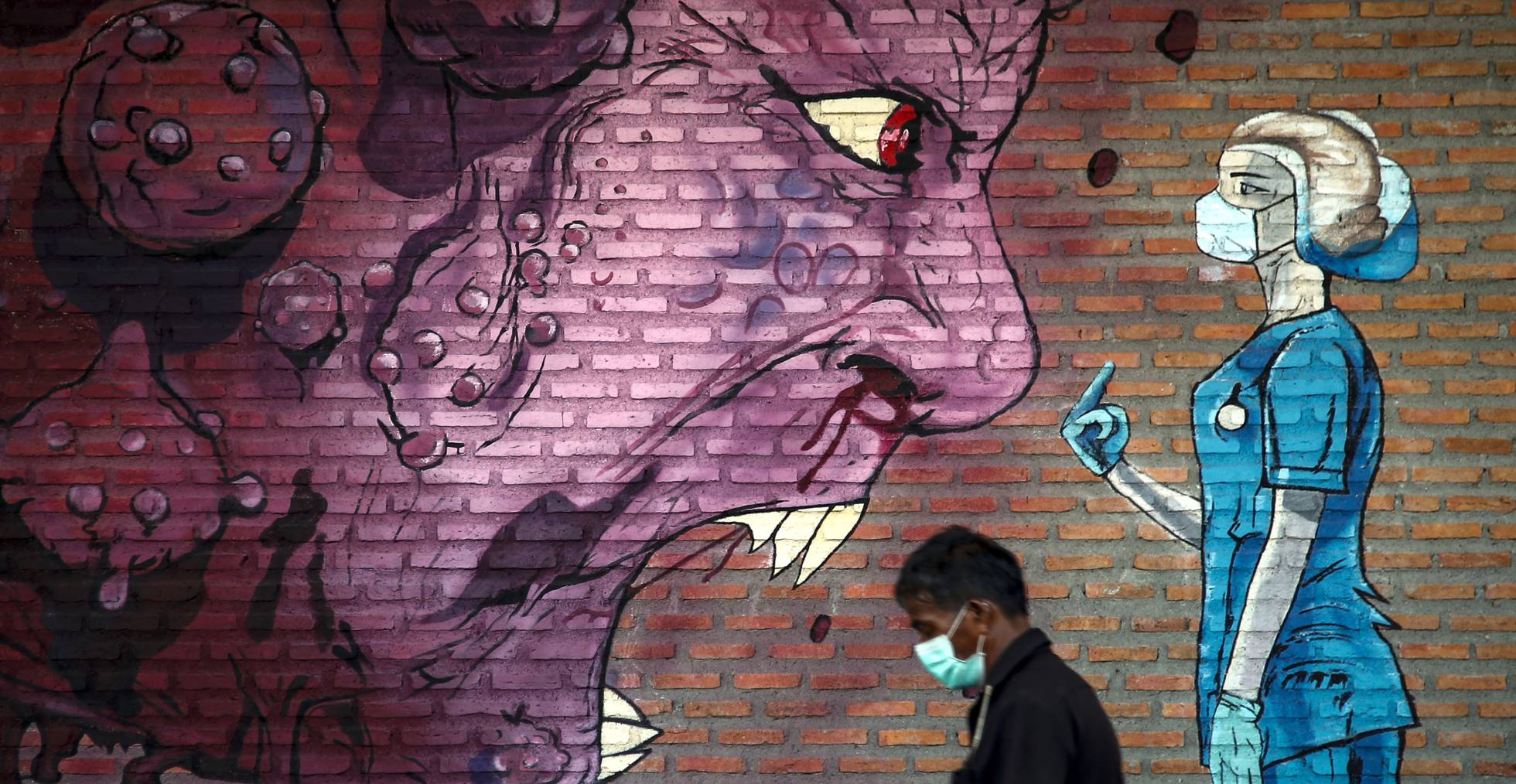 Un hombre pasa junto a un grafiti en un mercado de Bangkok (Tailandia).