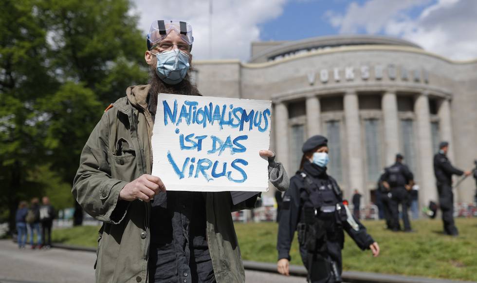 Un manifestante en Berlín sostiene un cartel con el lema “El nacionalismo es el virus”