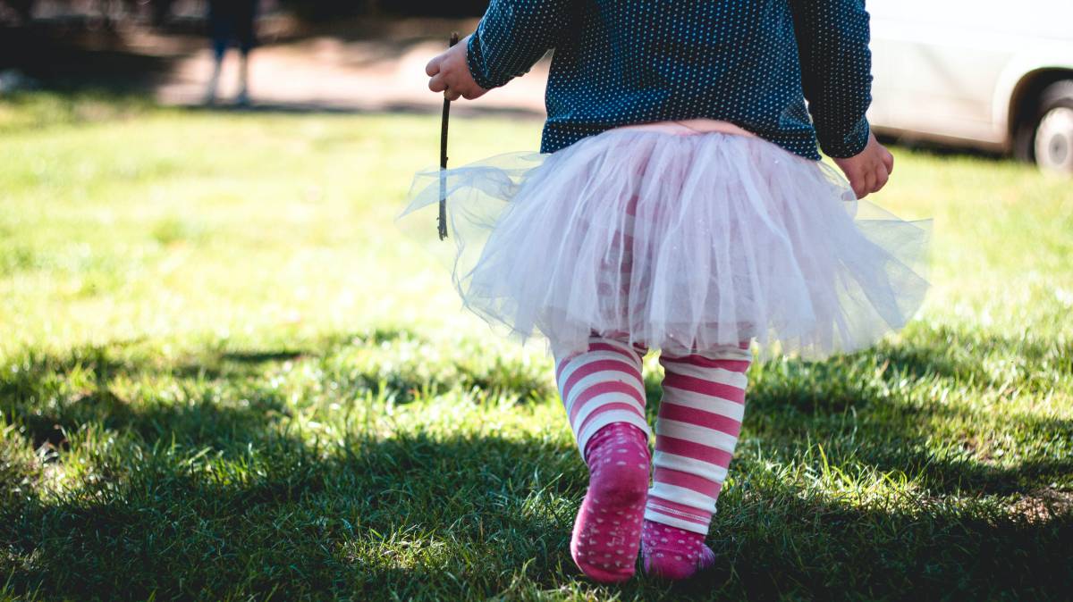 Una niña camina por su jardín.