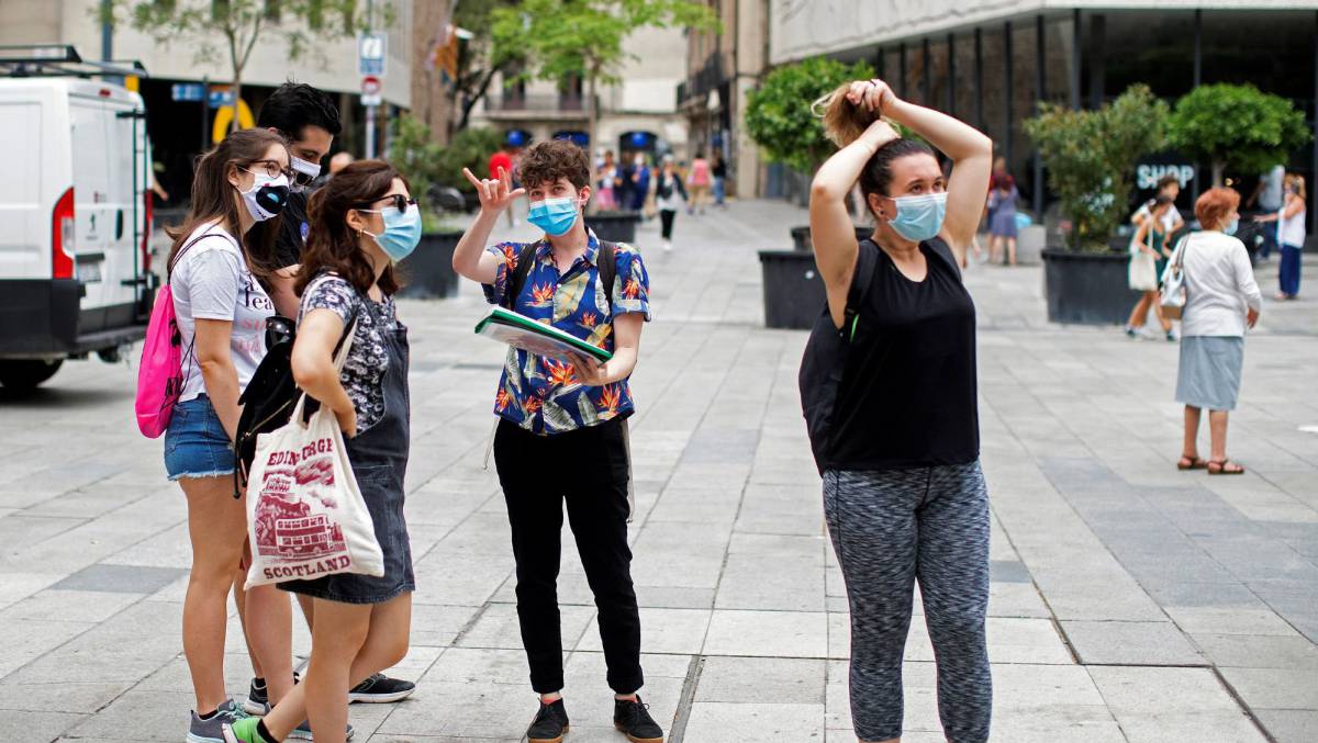 Un grupo de jóvenes atiende a las explicaciones de una guía turística este martes en la plaza de la Catedral de Barcelona.