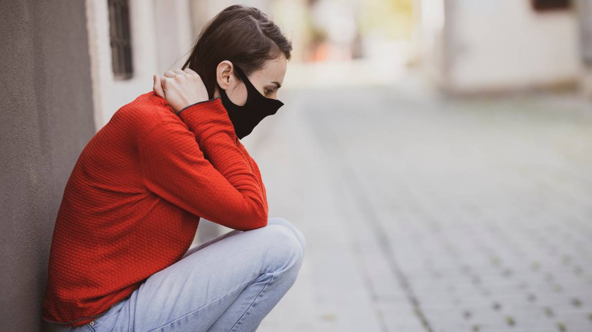Una mujer se sienta agotada en la calle.