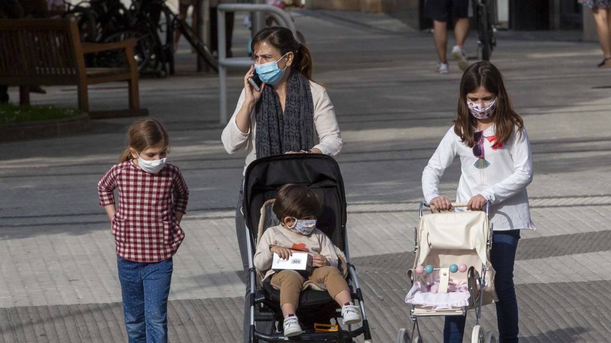 Una madre con tres niños, con mascarilla, pasea por San Sebastián. rn