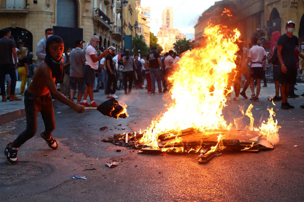 Un manifestante prende fuego a una barricada.