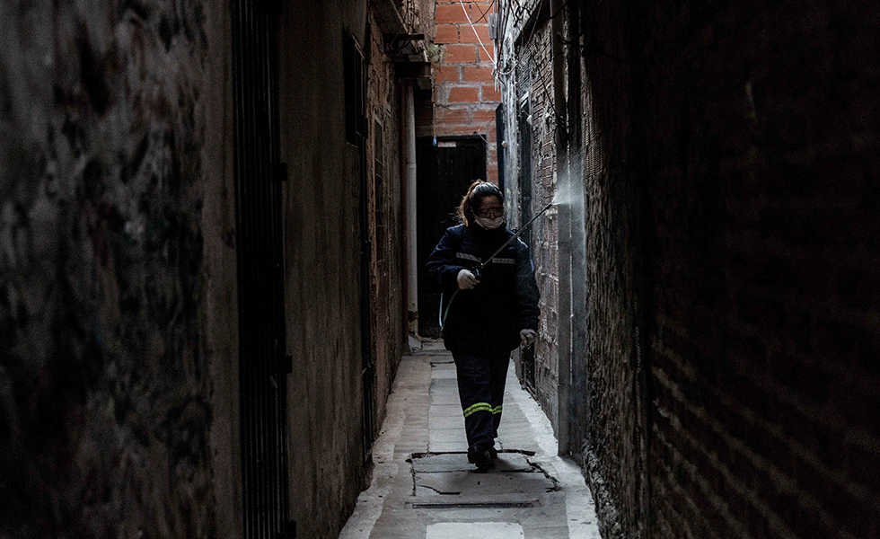 Susana Huallpa, de 48 años, llegó hace 18 a Buenos Aires desde Bolivia. Es parte de la cooperativa de limpieza de la organización que, en nombre del Estado, brinda un servicio barrial recolectando la basura y desinfectando los pasillos de la villa. Durante la pandemia, se contagió y pasó tiempo aislada en un hotel de la capital. Después, regresó con su familia y retomó su trabajo, que también incluye labores de comunicación de la organización.
