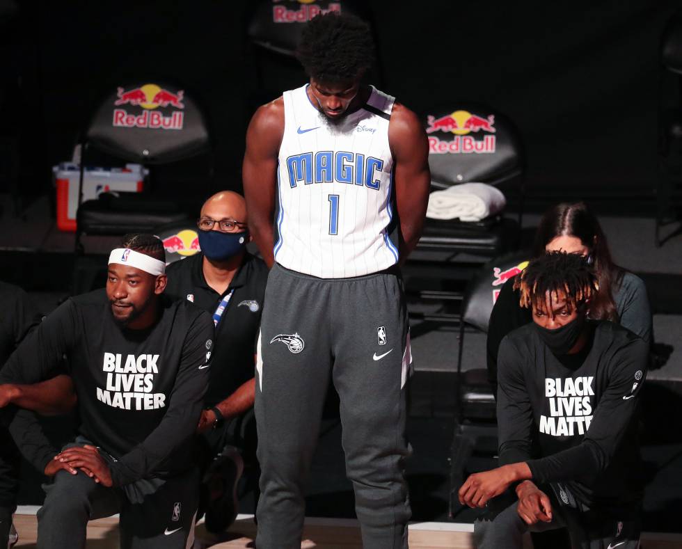 El jugador Jonathan Isaac (de pie en el centro) es el único de los Orlando Magic que no se arrodilla durante el himno ni lleva la camiseta con el lema