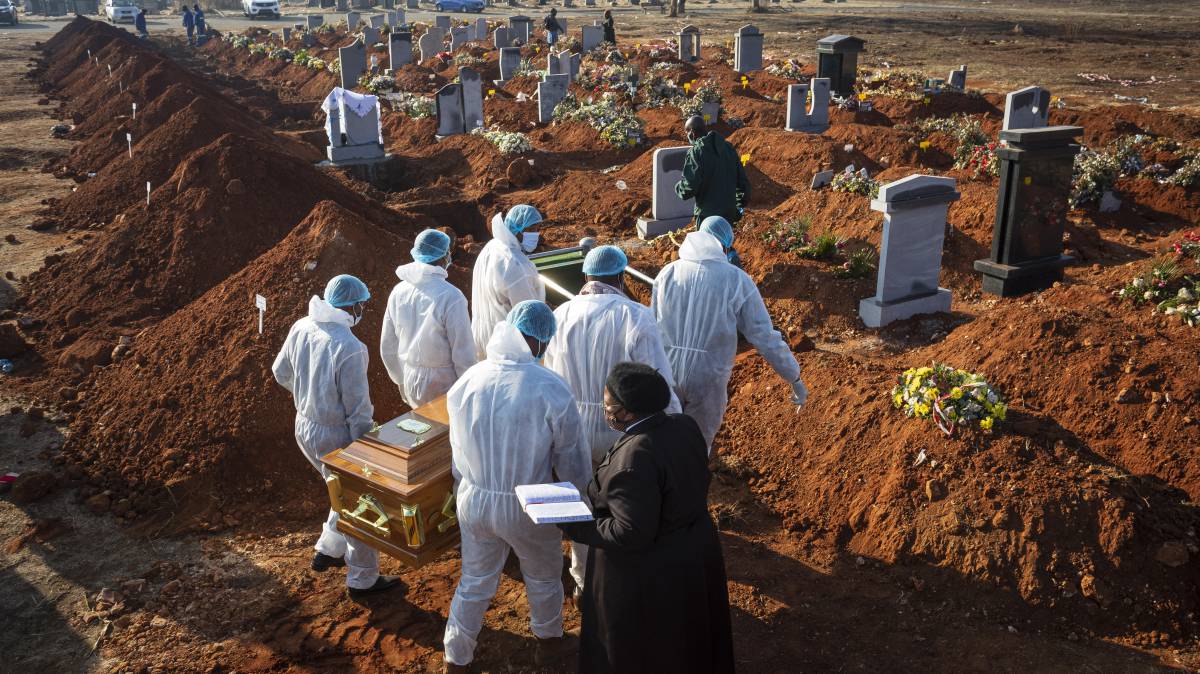 El ataúd de una víctima del virus Covid-19 Corona que fue llevado a su tumba por familiares en un cementerio de Johannesburgo (Sudáfrica) el 24 de julio de 2020