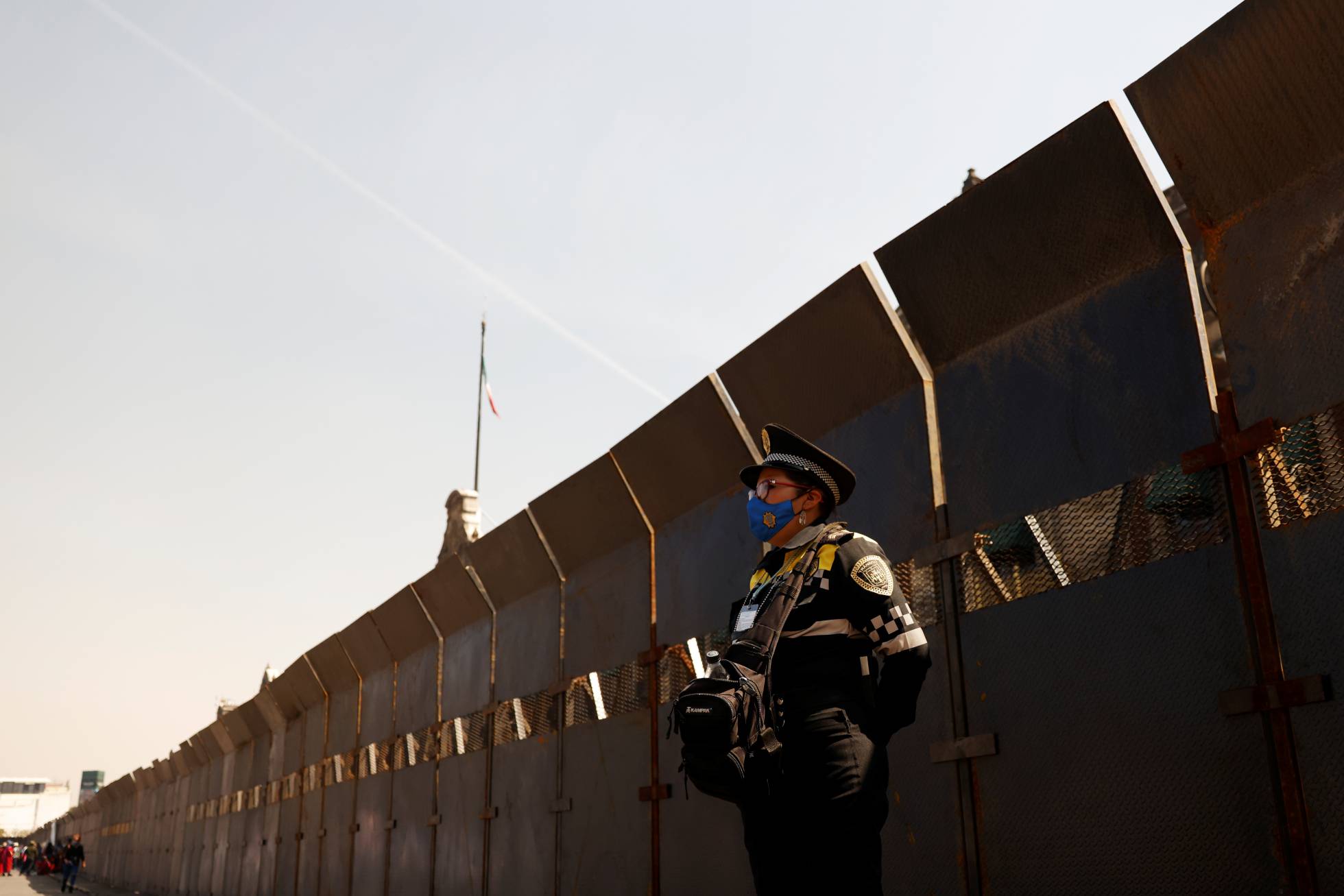 Un oficial de policía monta guardia junto a las cercas colocadas afuera del Palacio Nacional antes de la violencia esperada en una protesta por el Día de la Mujer, en la Ciudad de México