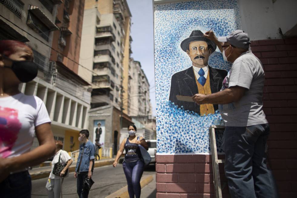Venezuelan artist Mervin Marmol puts finishing touches on his painting of late Venezuelan Dr. Jose Gregorio Hernandez at the street corner where he died in a car accident in 1919 in La Pastora neighborhood in Caracas, Venezuela, Monday, April 26, 2021. Known as the