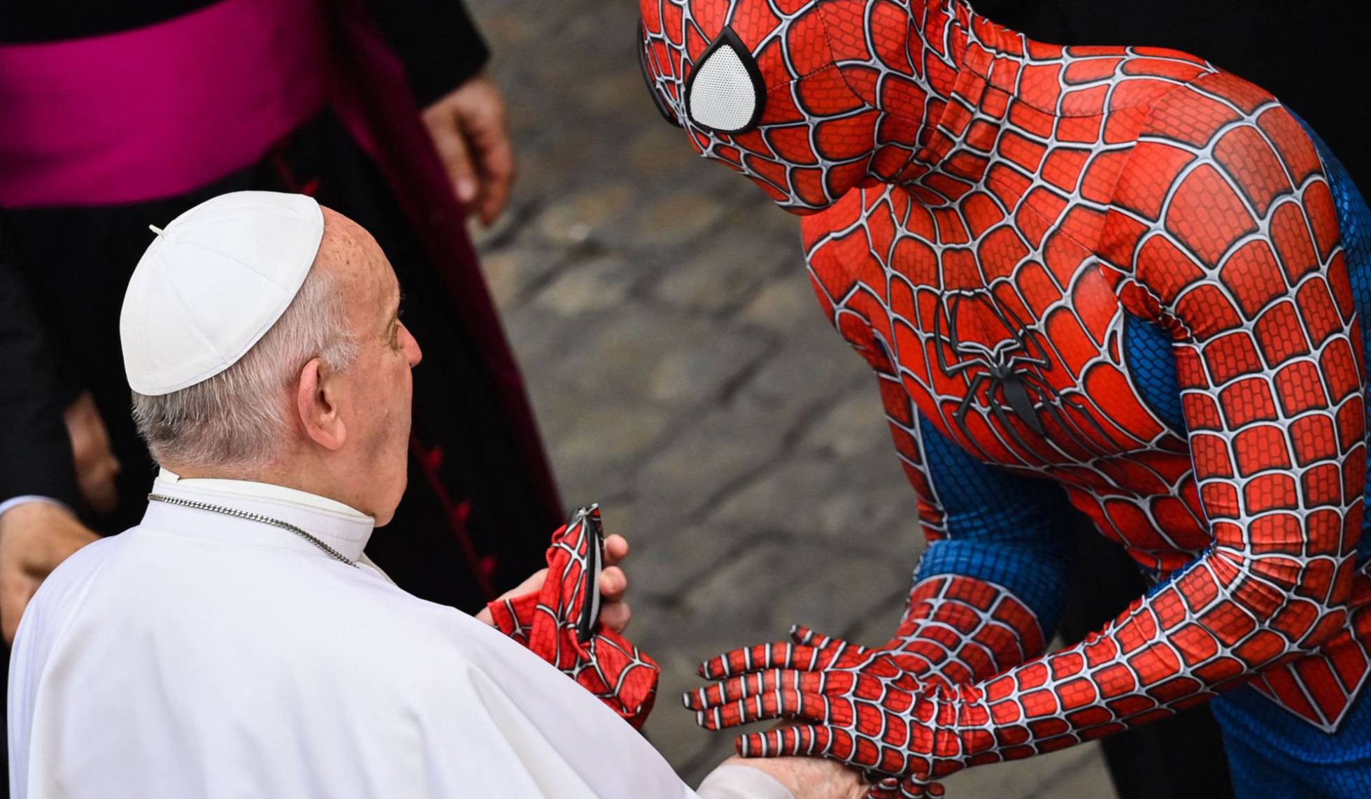 Un hombre con un disfraz del personaje Spider-Man, que actúa en hospitales para niños enfermos, entrega una máscara al papa Francisco al final de la audiencia general semanal, en el Vaticano.