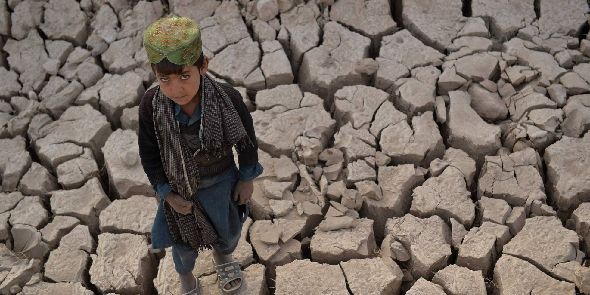 Un niño permanece sobre la tierra seca de Bala Murghab, Afganistán.