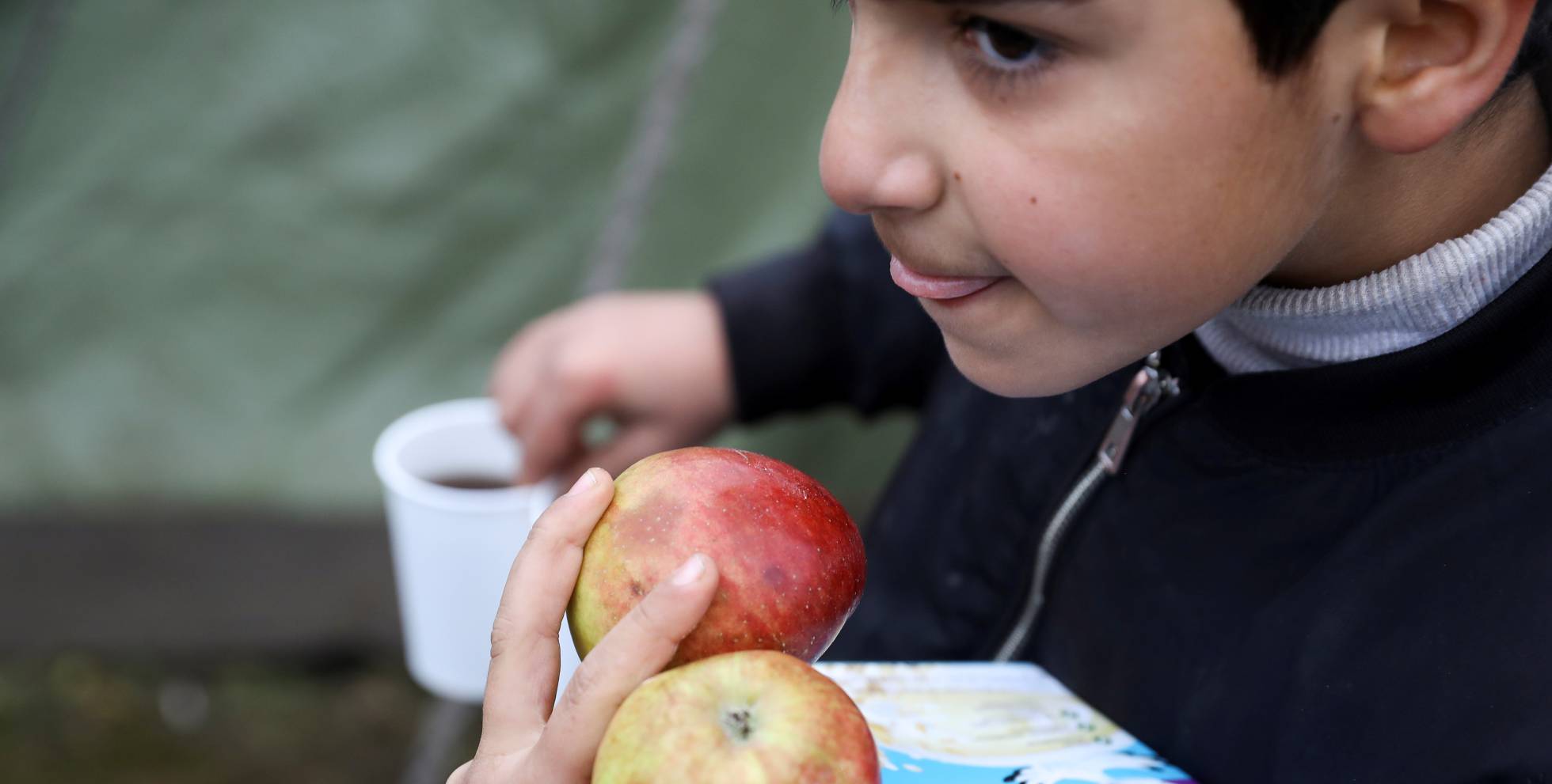 Un niño migrante lleva comida en un centro de transporte y logística cerca de la frontera entre Bielorrusia y Polonia, en la región de Grodno.rn rn