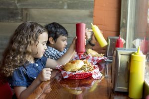 Niños comiendo la siempre eficaz hamburguesa.