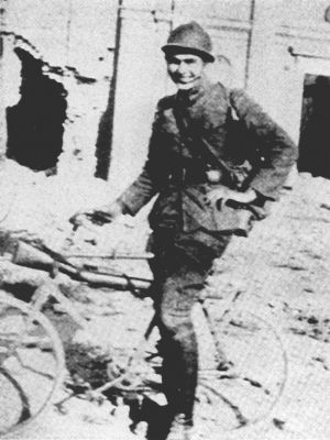 Ernest Hemingway con su bicicleta en Fossalta, frente a las ruinas de la iglesia.