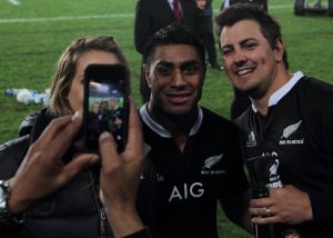 Aficionados fotografiándose con un jugador de los 'All Blacks' al finalizar el partido.