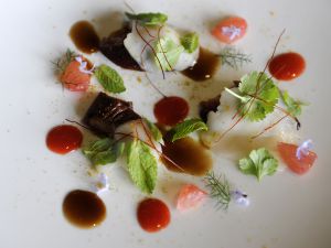 Oreja de cerdo, pez mantequilla, hierbas frescas y jugo.