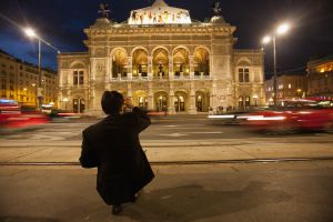 Un turista fotografiando el edificio de la ópera de Viena.