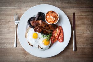 Desayuno inglés: huevos, beicon, salchichas y alubias con tomate.