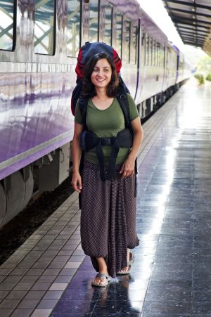 Una joven mochilera camina en una estación de tren.