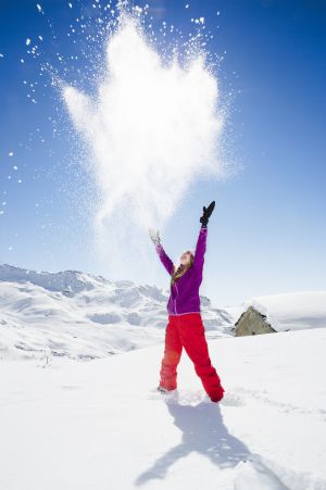 Una joven juega con la nieve.