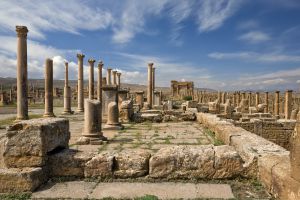 Ruinas de la colonia romana de Timgad, en Argelia, con el arco de Trajano al fondo.
