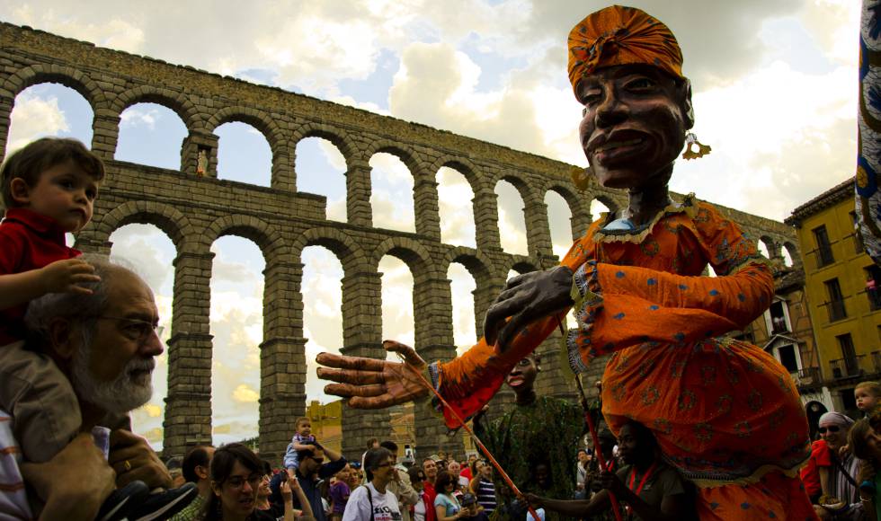 Marionetas de la compañia Boromo, de Burkina Faso, desfilan ante el acueducto de Segovia, durante la pasada edición del festival Titirimundi