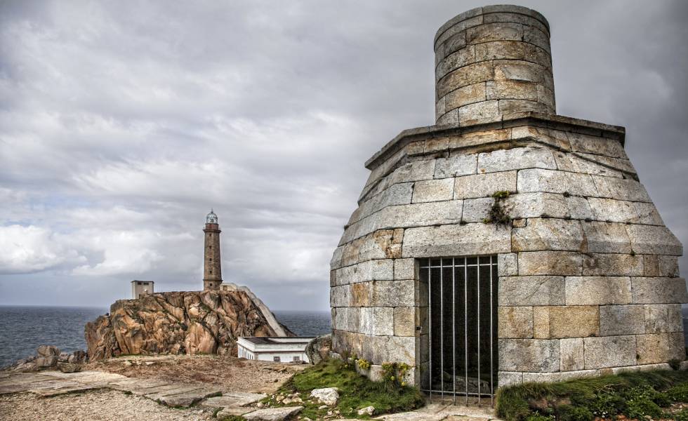 El faro de Vilán, al fondo, y la antigua linterna de aceite, en primer plano, en la Costa da Morte (A Coruña).