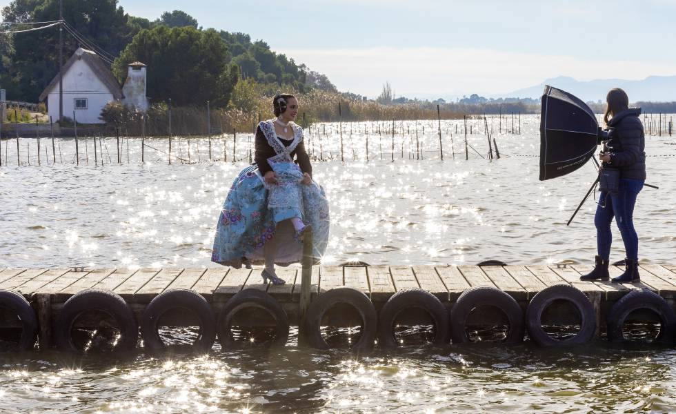Una fallera posa ante un fotógrafo en el embarcadero de la Gola de Pujol, en la Albufera de Valencia.