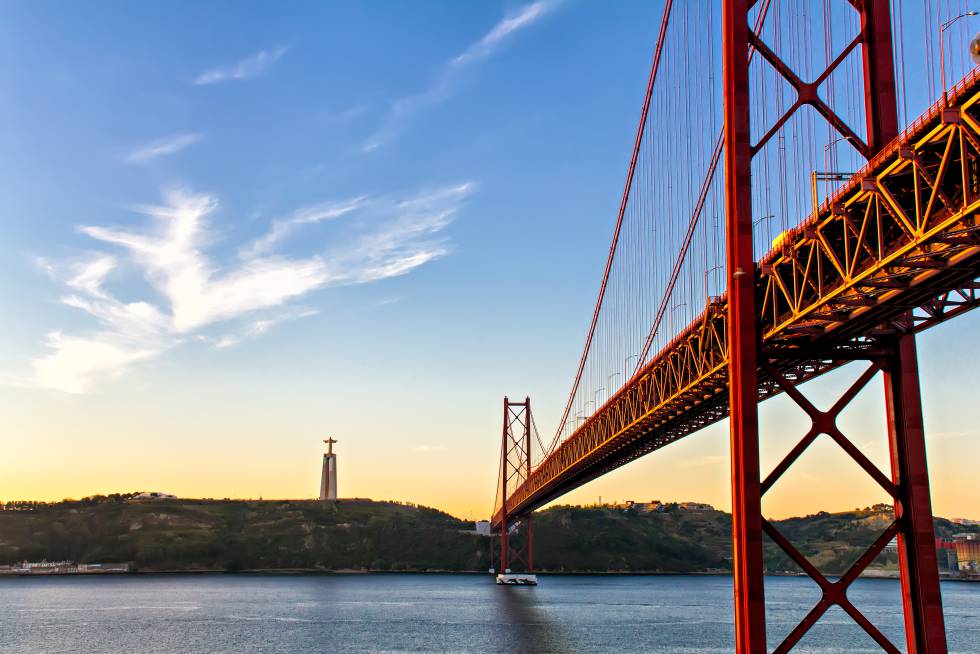 El puente 25 de Abril de Lisboa y, al otro lado del río Tajo, el santuario nacional de Cristo Rey.
