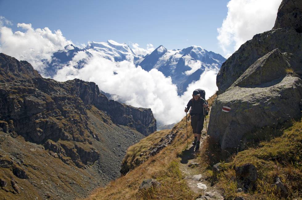 Un senderista en la Haute Route, con el Grand Combin, la montaña más alta de Alpes Peninos occidentales, al fondo.