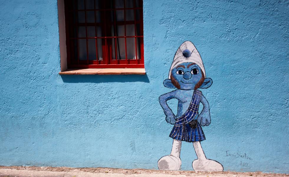 Arriba, un pitufo en una de las calles de Júzcar (Málaga).