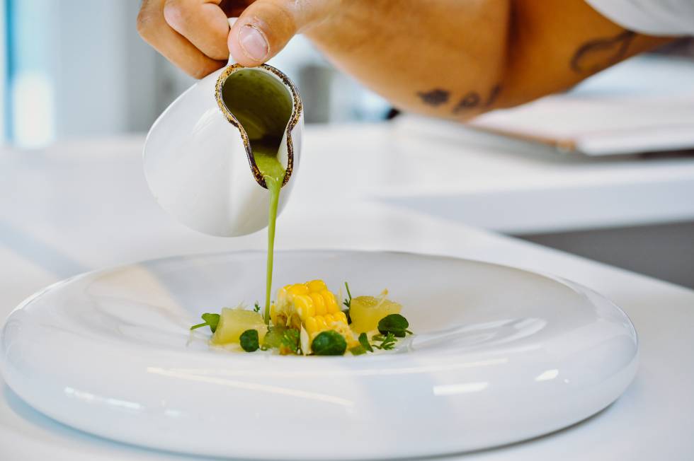Sopa de hierbas silvestres con crema de queso, pera confitada y millo.