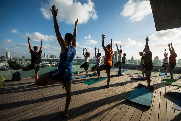 Clase de yoga en la azotea de la sede del Ayuntamiento de Tel Aviv, con el sky line de la ciudad al fondo