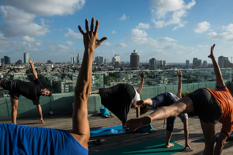 Clase de yoga en la azotea de la sede del Ayuntamiento de Tel Aviv, con el sky line de la ciudad al fondo