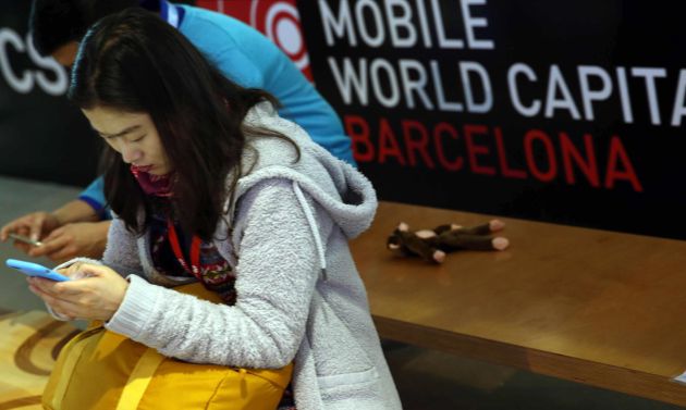 Una mujer utiliza su m&oacute;vil en el MWC de Barcelona. 