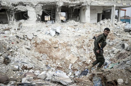 Un combatiente kurdo camina entre los escombros de un edificio en el centro de la ciudad siria de Kobane, este miércoles.