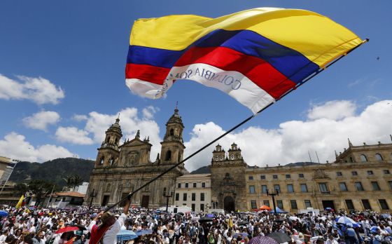 Un hombre agita una bandera colombiana durante la