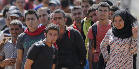 Un grupo de refugiados esperan para cruzar la frontera entre Macedonia y Grecia