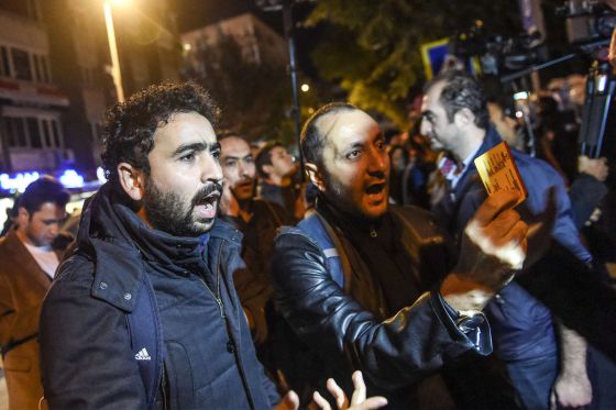 Periodistas enseñan su carné de prensa a policías de paisano en Turquía