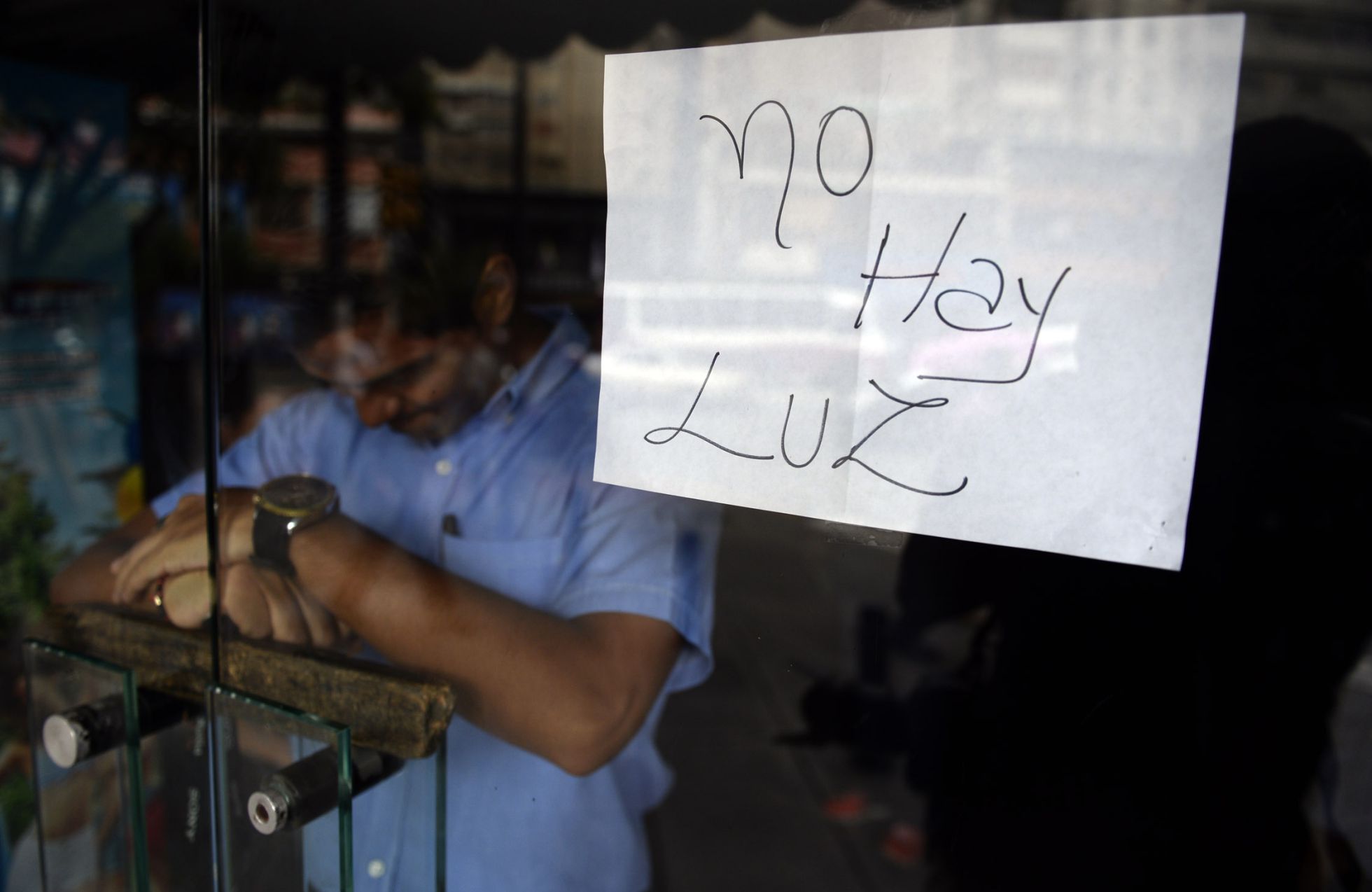 Un empleado, tras la puerta de un comercio cerrado en Caracas. Un empleado, tras la puerta de un comercio cerrado en Caracas.