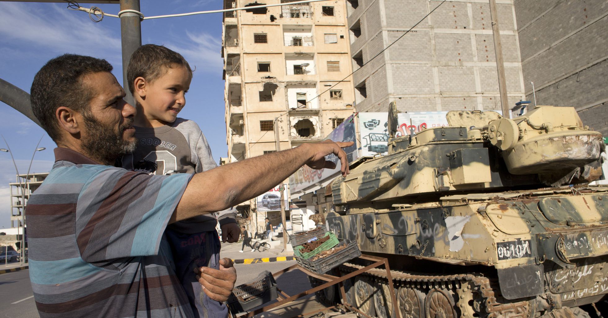 FOTOGALERÍA: VIAJE A MISRATA | Jalid Shabha mira junto a su hijo los tanques de la avenida Trípoli, en Misrata. FOTOGALERÍA: VIAJE A MISRATA | Jalid Shabha mira junto a su hijo los tanques de la avenida Trípoli, en Misrata.