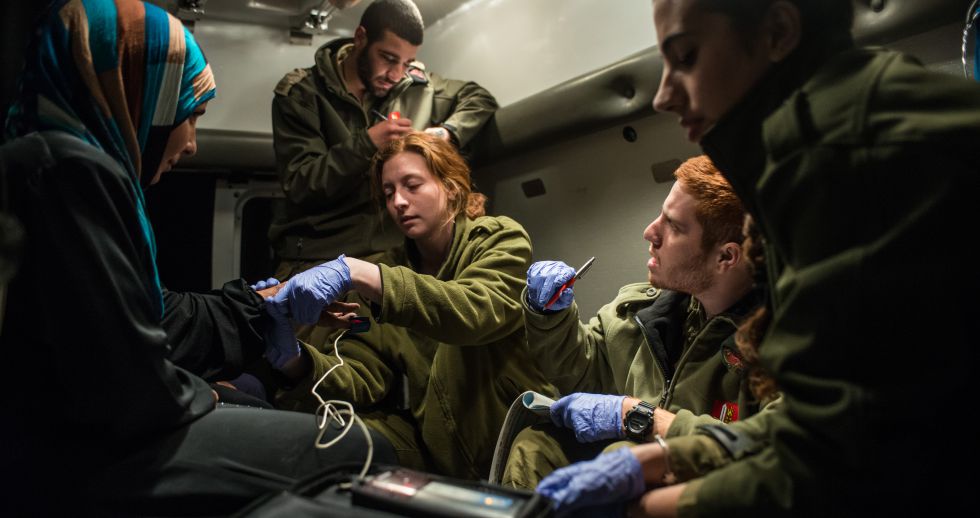 Militares paramédicos israelíes atienden a un grupo de sirios en los Altos del Golán. Militares paramédicos israelíes atienden a un grupo de sirios en los Altos del Golán.