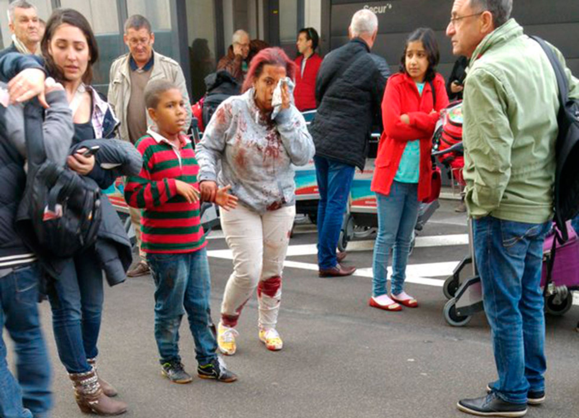 Una mujer herida abandona el aeropuerto de Bruselas tras las explosiones. Una mujer herida abandona el aeropuerto de Bruselas tras las explosiones.