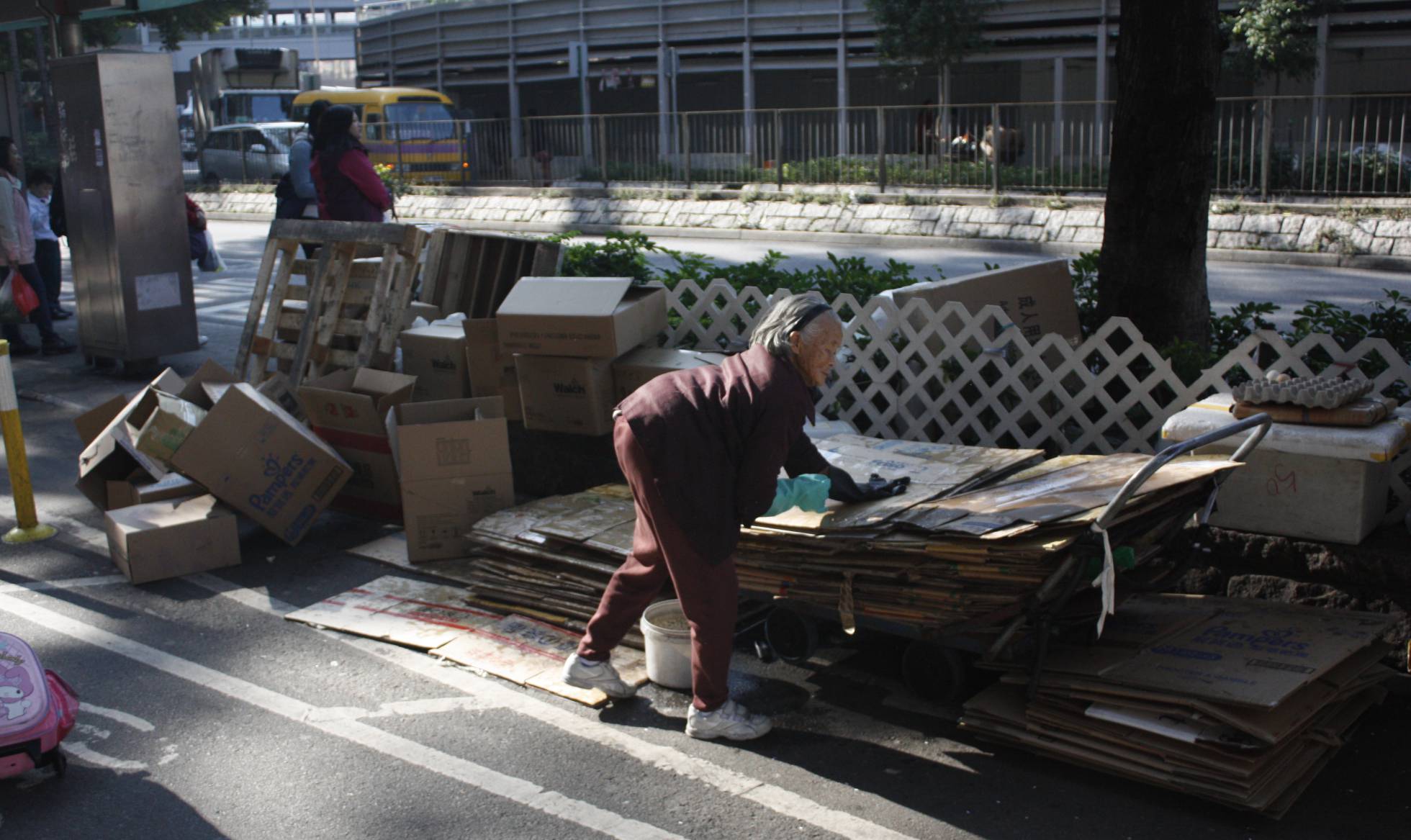 Mulher coletando papelão no bairro de Sheung Shui. Mulher coletando papelão no bairro de Sheung Shui.